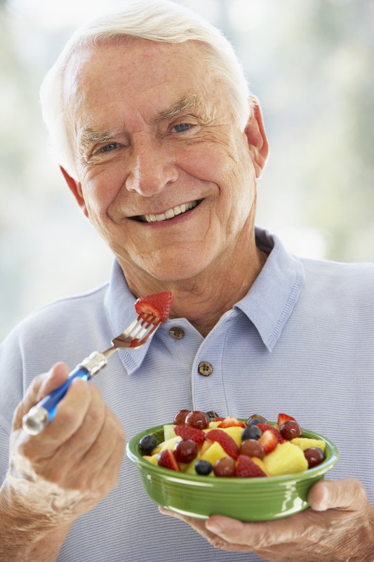 Senior man eating fruit as part of care for seniors stroke prevention